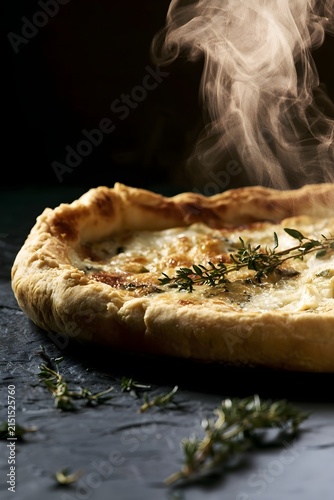 Whole Goat Cheese Tart Low-Angle View with Curling Steam and Thyme
