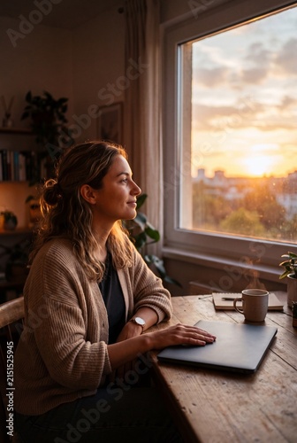 Person closing laptop at sunset with warm light symbolizing end of workday for work life balance concept