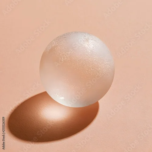 Fototapeta samoprzylepna Geometric frosted glass sphere on pale peach background