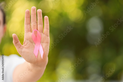 Картината върху платно Person holding a pink ribbon in their palm, breast cancer awareness and support,