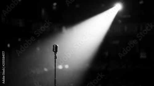 Mic stands alone under bright stage spotlight