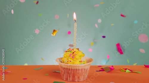 Birthday Cupcake with Lit Candle and Colorful Confetti Celebration