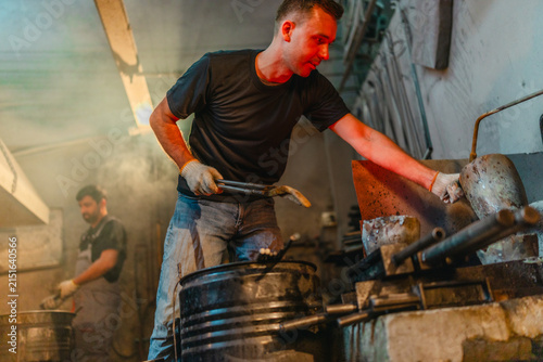 Foundry Workers Pouring Molten Metal in Traditional Casting Workshop