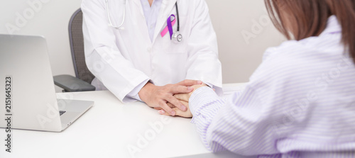 doctor hold patient hand to comfort and support with empathy. purple and pink ribbon concept of September Thyroid Cancer Awareness month, Healthcare and February world cancer day