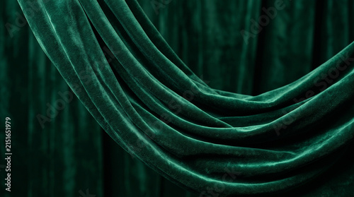 Emerald green velvet fabric background. Luxurious draped textile with soft wavy folds.