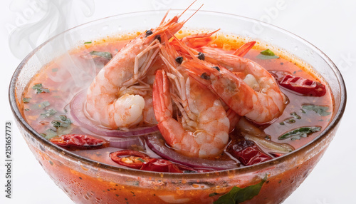 Spicy soup shrimp tom yum Thai cuisine hot chili herb aromatic Spicy soup with shrimp tom yum Thai cuisine hot chili aromatic herb red onion fresh cilantro and steaming broth in clear bowl