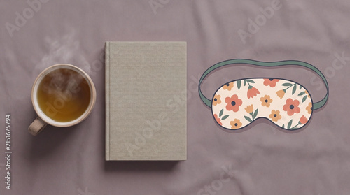 Relaxing morning concept with hot tea book and floral sleep mask