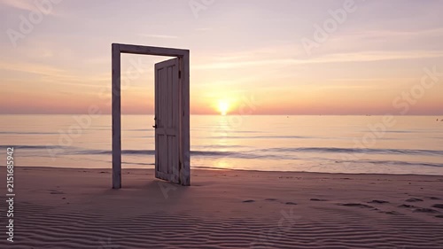 Open door frame standing on sandy beach at sunset.