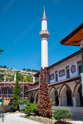 Photography The inner courtyard of the Khan’s Palace in Bakhchisaray, with a minaret in the background, on a clear, sunny day