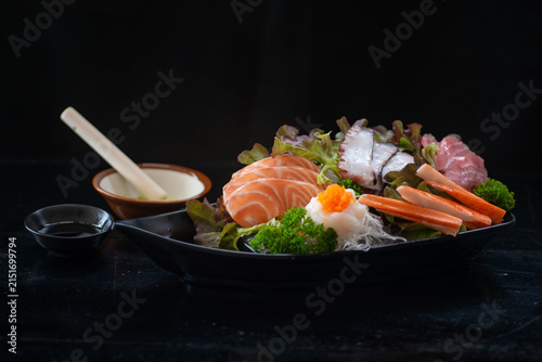 Sashimi set includes salmon, shrimp, octopus, and other ingredients, beautifully arranged on a plate – a classic Japanese culinary concept.