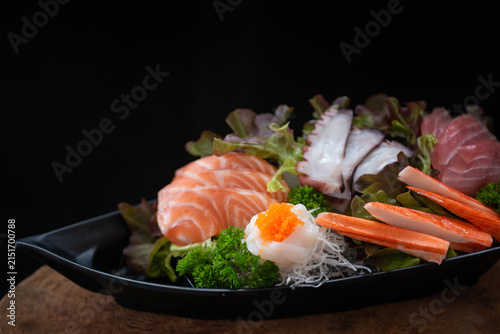 Close up, Sashimi set includes salmon, shrimp, squid, and other ingredients, beautifully arranged on a plate – a classic Japanese culinary concept.