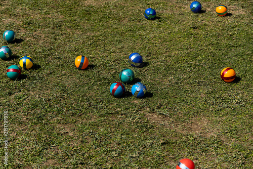 Colorful plastic balls on grass during an outdoor game event in bright sunlight