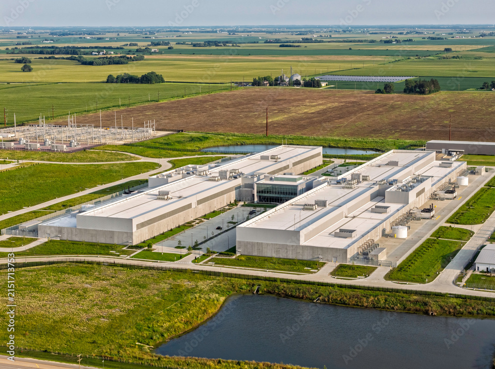 Fototapeta premium Aerial view of huge data center facility with rooftop cooling units and surrounding industrial infrastructure in DeKalb, Illinois