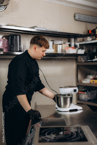 Young male chef preparing food using stand mixer