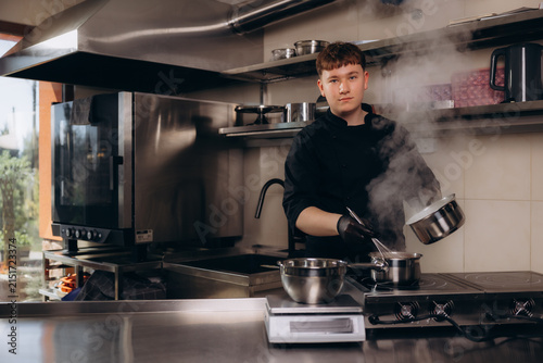 Young chef in commercial kitchen preparing food