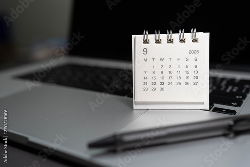 SEPTEMBER 2026 small desk calendar on laptop workspace with pen on office table. business scheduling, time management, event planning, deadline tracking, work efficiency, and corporate organizing.