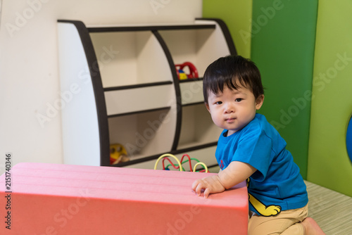 Obraz na plátně キッズルームのピンクのソフトブロックにもたれている日本人の男の赤ちゃん