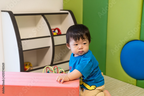 Fotografie キッズルームのピンクのソフトブロックにもたれている日本人の男の赤ちゃん