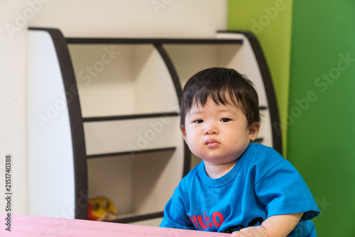Bild auf Leinwand キッズルームのピンクのソフトブロックにもたれている日本人の男の赤ちゃん