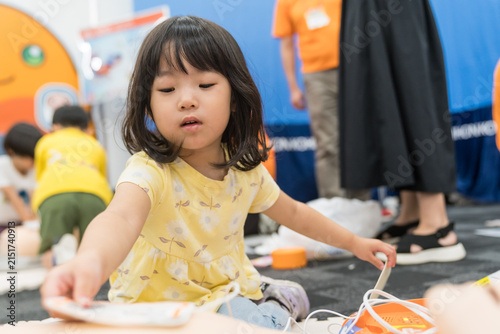 救急救命体験イベントでAEDに触れる日本人の女の子の幼児