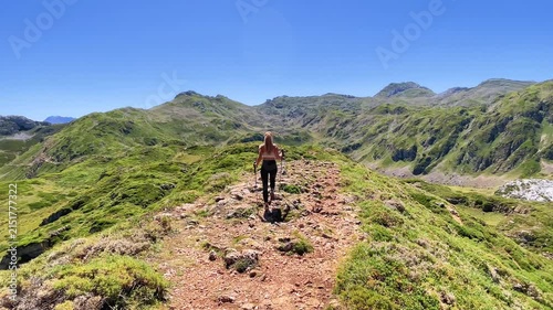 young woman walking on mountain trail trail ridge in summer landscape