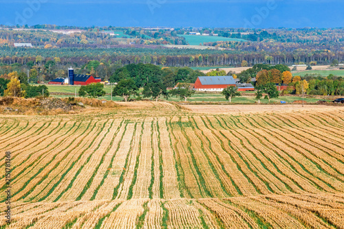 View at a rural landscape with fields and red barns in autumn