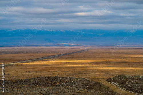 Panoramic view of Chuya steppe and Altai mountains under dramatic cloudy sky, Russia
