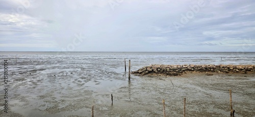 Concrete Mooring Posts and Rock Breakwater Wall at Low Tide, Small Boat Navigation Channel for Local Fishermen.
