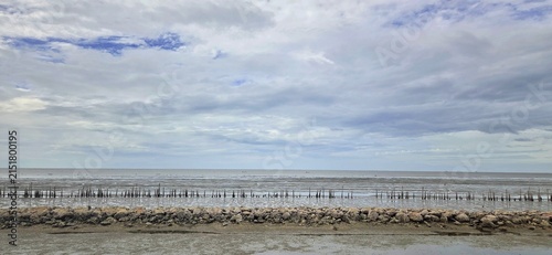 Rock Breakwater Barrier and Bamboo Wave Breaker Wall Built for Coastal Erosion Control Along Shoreline.