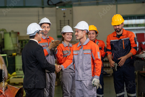 Engineer factory worker hardhat handshake safety team industry uniform group in workshop during industrial meeting