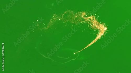 A glowing golden trail of magical particles on green background