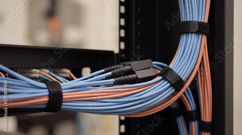 Fotografía Close-up of vibrant blue and orange network cables neatly bundled with velcro ties within a server rack for efficient
