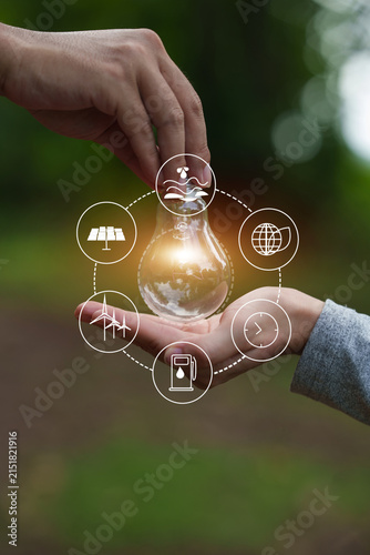 Hands Holding Glowing Lightbulb with Sustainability Icons