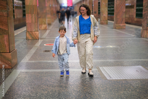 Photography Woman walking with kid in subway station