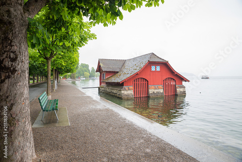 Bild auf Leinwand lakeside promenade Luzern with chestnut trees, historic red boathouse