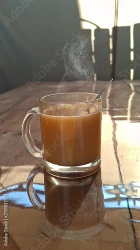 glass cup with hot cacao on wooden table in rustic country house at sunrise, cozy morning beverage and tranquil rural lifestyle concept vertical video format