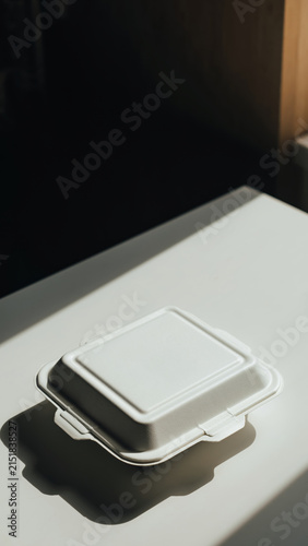 White food container with lid on a white surface.