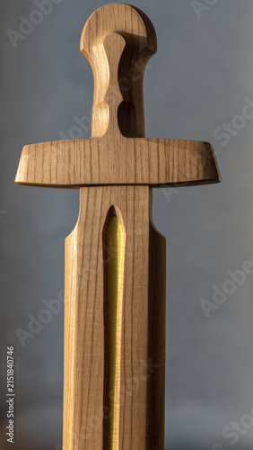 Wooden sword-shaped object with a gold-colored element inside.