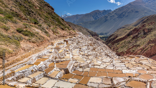 Traditional terraced salt ponds of Salineras de Maras cascading down the Andean mountainside with vibrant mineral colors and dramatic valley scenery