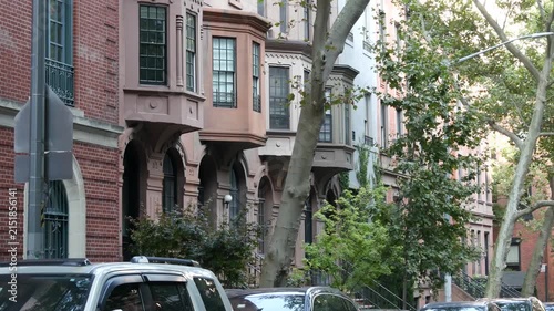 New York City townhouse buildings, brownstone row houses in Manhattan or Brooklyn, United States of America. Classic buildings on residential district street. Real estate property. Rowhouse townhome.