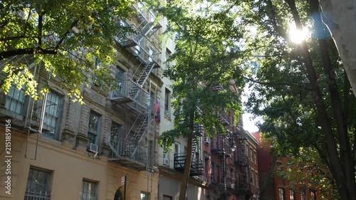 New York City urban residential buildings architecture, Manhattan classic street, United States of America. Typical red brick house in NYC, real estate property in USA. Fire escape metallic ladder.