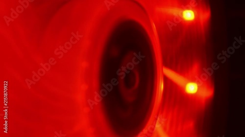 Computer cooling fan with glowing red led light spinning fast. Modern hardware cooling component in operation. High speed pc ventilation system for gaming desktop.