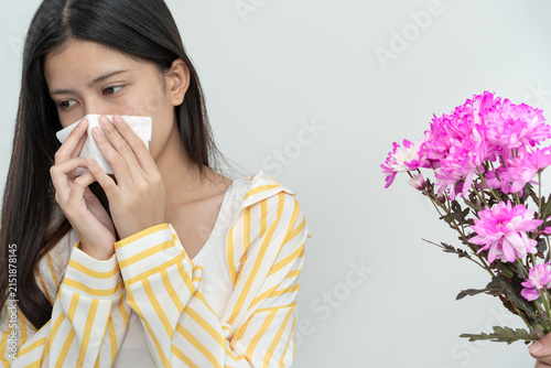 Obraz na płótnie Pollen Allergies, asian young woman sneezing in a handkerchief or blowing in a wipe, allergic to wild spring flowers or blossoms during spring