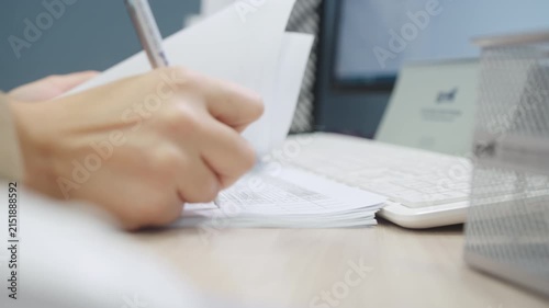 Office worker flips white paper pages on wooden table. Motion blur dynamic effect highlights fast business documentation review process