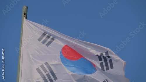 Taegeukgi - the national flag of South Korea is fluttering in the wind against the clear blue sky. Freedom, politics, patriotism, diplomacy and international affairs concept