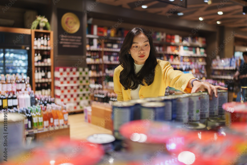 Obraz premium Woman shopping for products in a modern supermarket