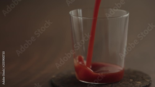 Slow motion pour tomato juice in a glass
