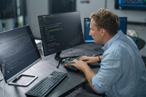 Male programmer coding on computer monitors in modern office, Software development, professional engineer working on future technology business innovation, cyberspace and digital system