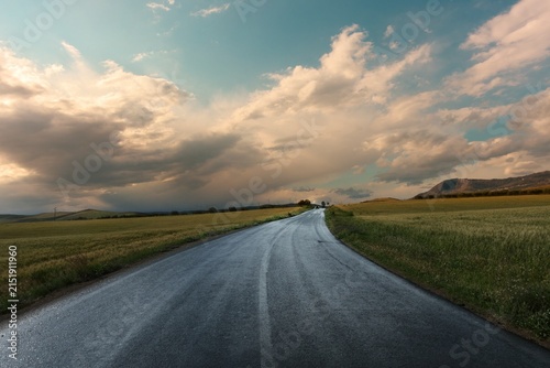 clearing up of dramatic sky after the rain on rural road of Sicily at the sunset in Italy