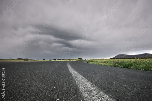low angle view white line country road below a gloomy sky in Sicily, Italy